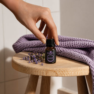 Mano tomando el aceite esencial de Lavanda 11 ml junto a flores de lavanda | Exotik Nat