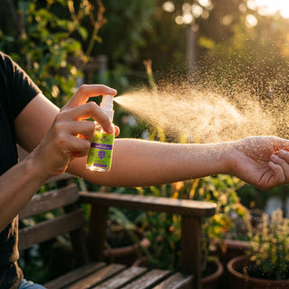 Persona rociando el spray de citronela Exotik Nat en el brazo al aire libre